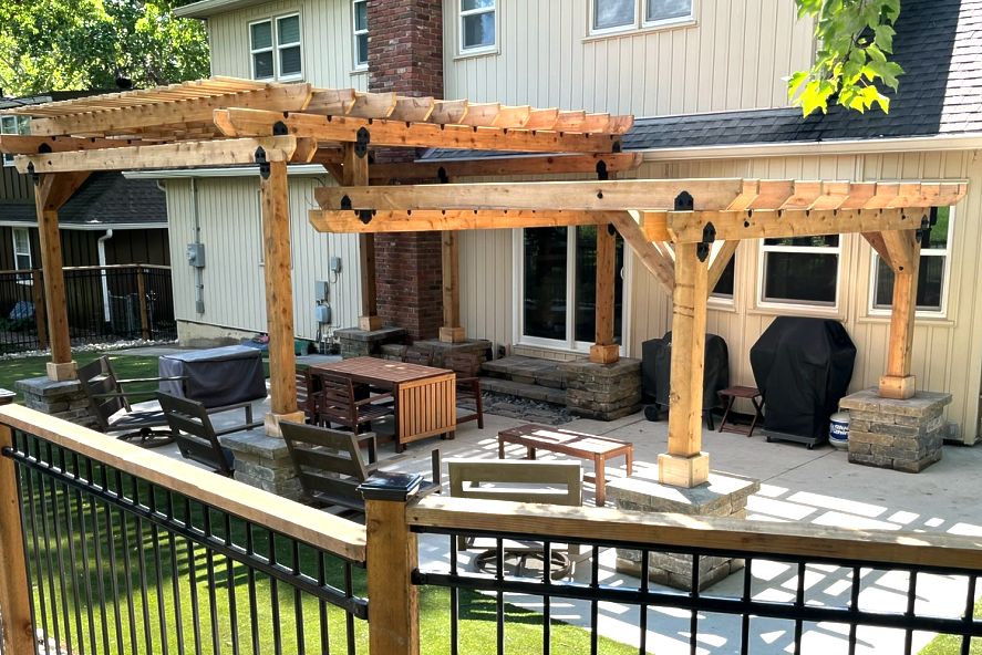 Cedar pergola over a paver patio with outdoor seating in the Kansas City area